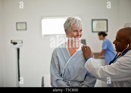 Femme mature l'objet d'un examen médical avec son médecin. Banque D'Images