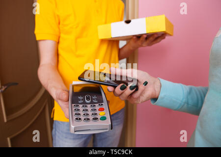 Femme paie pour pizza téléphone à clavier NIP par courrier Banque D'Images