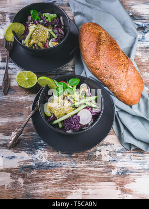 Ciabatta italien salade de légumes frais et sombre dans un bol. Avec salade de radis, chou rouge, concombre, le pesto et les graines de sésame. Banque D'Images