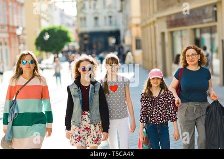 Groupe de filles marcher à travers le centre-ville, les mères et filles ensemble sur un voyage de shopping. Banque D'Images