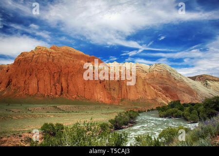 Paysage avec rivière et montagnes rouges. L'heure d'été. Le Kirghizistan. La vallée de la rivière Kekemeren Suusamyr Banque D'Images