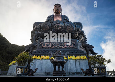 Statue de Bouddha au sommet au coucher du soleil dans les nuages. Statue du Grand Bouddha au sommet de la montagne de Fansipan, Sapa, Lao Cai, Vietnam. Légende Fansipan spectaculaire Banque D'Images