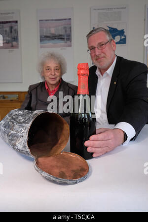 23 avril 2019, la Saxe-Anhalt, Nebra : Le maire de Nebra, Antje Scheschinski, et Mike Eberle, directeur général de l'Rotkäppchen Sektkellerei, assis devant une vieille bouteille de vin pétillant et la time capsule d'un chantier de construction de la salle polyvalente. Sur 24.08.2018 la capsule a été découvert pendant les travaux de construction sur un pont à Unstrut Engelberg. A l'intérieur, il y avait une bouteille de champagne de la marque 'Kloss & Foerster', l'ancêtre du Petit Chaperon Rouge - parmi d'autres témoins contemporains. La cave à vin mousseux a acquis la bouteille pour ses archives, l'argent est utilisé à des fins charitables pu Banque D'Images