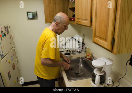 Syracuse, NY, USA. 21 mai, 2011. Gary Nye, 68 ans, a vécu de nombreuses années dans les hôpitaux de l'état en raison de sa déficience intellectuelle. Il vit seul dans un immeuble à appartements à Syracuse, NY, avec l'aide de divers organismes sans but lucratif que l'aider à naviguer dans la société en dehors des murs de l'hôpital. Crédit : Robin Rayne/ZUMA/Alamy Fil Live News Banque D'Images