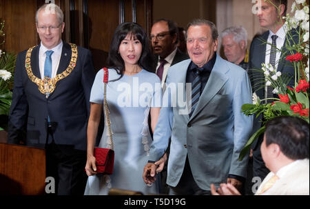 Dpatop - 24 avril 2019, Basse-Saxe, Hanovre : l'ancien chancelier allemand Gerhard Schröder (2e à partir de la droite, SPD) vient avec son épouse Kim Soyeon et Lord Mayor Stefan Schostok (l, SPD) à une réception de la ville de Hanovre, l'occasion de son 75e anniversaire dans la nouvelle mairie. Photo : Julian Stratenschulte/dpa Banque D'Images