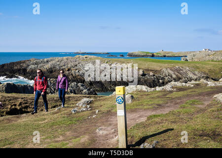 Deux personnes marchant sur l'île d'Anglesey sentier côtier de Rhoscolyn, Ile d'Anglesey, au Pays de Galles, Royaume-Uni, Angleterre Banque D'Images