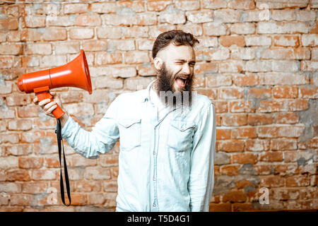 Beau barbu avec haut-parleur rouge sur le mur de brique background Banque D'Images