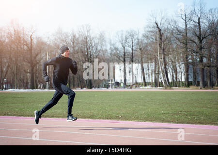 Photo de l'homme sportif qui traverse stadium au printemps jog Banque D'Images