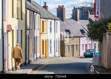 Un vieil homme avec un bâton marche le long de la Mount Pleasant Road, Bangor, Anglesey, Pays de Galles, Royaume-Uni Banque D'Images