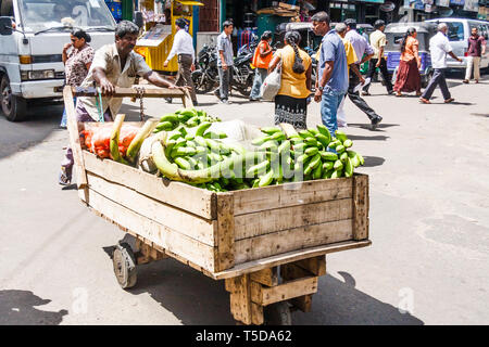 Colombo, Sri Lanka - 16 mars 2011 : Man pushing panier plein de bananes par rue animée dans le quartier de Pettah. C'est la zone de marché et de négociation Banque D'Images