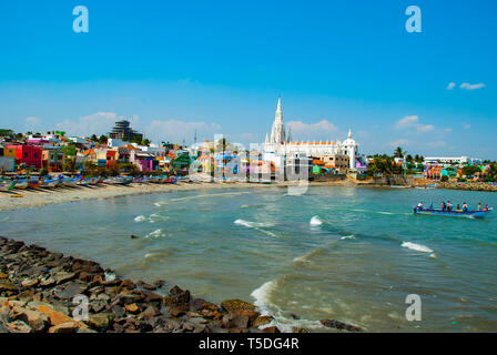 Kanyakumari, Inde - Janvier 26,2019:Notre Dame de rançon de culte Église derrière maisons colorées sur une plage de sable occupée par les bateaux de pêche à Kanyakumari Banque D'Images