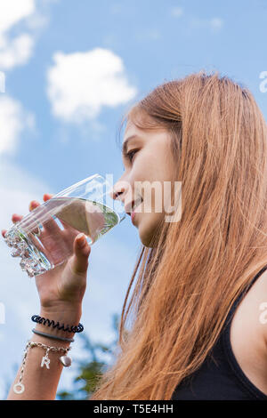 Adolescente de boire un verre d'eau Banque D'Images