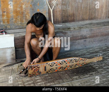 Orang Ulu faire un homme tribal sape (luth traditionnel), Sarawak Cultural Village, Kuching, Sarawak (Bornéo), Malaisie Banque D'Images