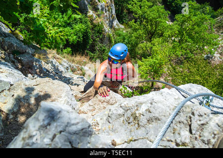 Aventureux, femme courageuse climber en via ferrata vélo appelé 'Casa Zmeului', une attraction touristique populaire près de Vadu Crisului, Roumanie. T Active Banque D'Images