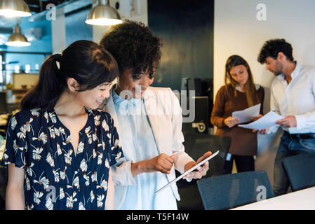 Smiling businesswomen using digital tablet in office Banque D'Images
