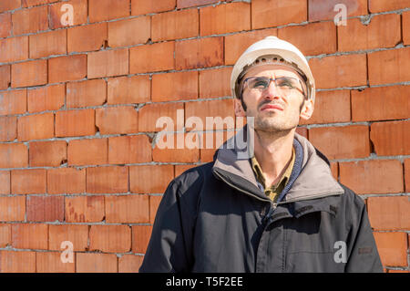 Portrait d'un jeune ingénieur civil wearing hardhat on construction site Banque D'Images