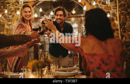 Les amis de grandes partie dans la nuit. Groupe de personnes toasting wine au cours d'un dîner de travail. Banque D'Images