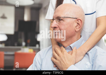 Syndicat de la santé et d'un senior au cours de visite à domicile. Heureux patient est tenue pour un fournisseur de main tout en passant du temps ensemble Banque D'Images