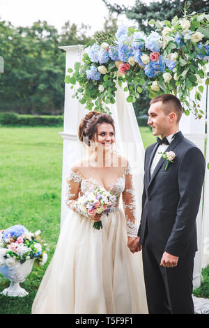 Amazing wedding couple près de l'arche de mariage . L'époux et épouse dans l'amour Banque D'Images