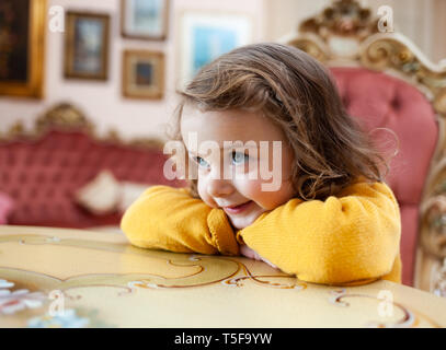 Portrait de jeune fille tout-petit dans un salon avec décor baroque. Banque D'Images