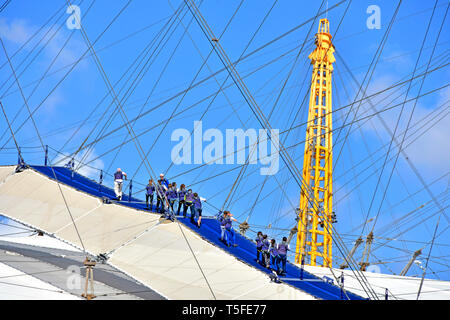 Jusqu'à l'O2 Arena de toit dôme du millénaire et toit Skywalk à pied groupe de personnes porter des blouses bleus d'escalade haut de O2 arena tour leader guide UK Banque D'Images