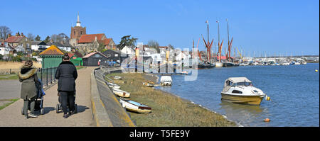 Les mamans et la pram marche-Promenade Riverside hiver panorama du parc à côté de l'estuaire de la rivière Blackwater à marée haute tamise les chalands au-delà de Maldon Essex England UK Banque D'Images