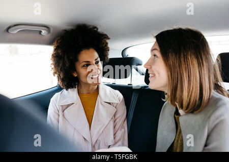 Deux femmes heureux assis en arrière d'une voiture Banque D'Images