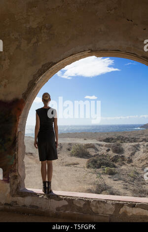 Espagne, Ténérife, Abades, Sanatorio de Abona, woman standing at fenêtre cintrée dans Ghost Town building Banque D'Images