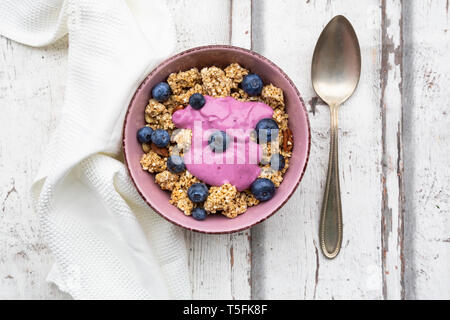 Barres granola avec yogourt aux bleuets Les bleuets et le bol en bois blanc sur Banque D'Images