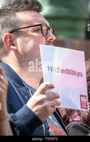 Un homme est vu holding a placard alors que la fierté d'un drapeau est vu sous l'ses lunettes pendant la veillée. Peuple pour rendre hommage au journaliste né à Belfast Lyra McKee, 29, qui a été abattu par des membres de la nouvelle alors que l'IRA tout en couvrant des émeutes qui se produisaient à Derry, également connu sous le nom de Londonderry. Le NUJ Glasgow Direction générale a présenté un vigile pour ceux qui souhaitent rendre hommage à la journaliste tué. Banque D'Images