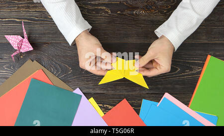 Man holding papier jaune papillon. Banque D'Images