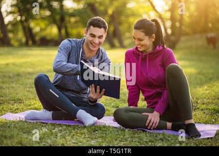 Thérapeute physique est montrant des exercices pour la sciatalgie récupération pour les jeunes patients. Banque D'Images