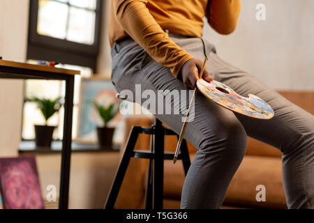 Gros plan d'une palette de couleurs dans la main des peintres Banque D'Images
