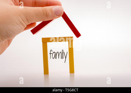 Hand holding pièces domino formant une forme de maison Banque D'Images