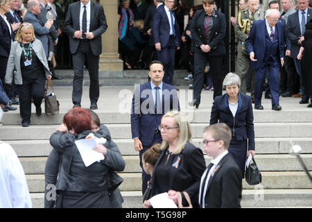 Belfast, County Antrim, Northern Ireland, 24 avril, 2019 - Premier ministre britannique Theresa May et Taoiseach Irlandais, Leo Varadkar regardez sur la famille en tant que parents de Mme Lyra McKee hug à l'extérieur à St Anne's Cathedral, Donegall Street, Belfast après les funérailles de Mme McKee. Mme McKee, un des journalistes, 29, a reçu une balle dans la tête jeudi soir tout en observant des émeutes au Cœur du domaine Creggan. La nouvelle IRA a admis la responsabilité de l'assassinat du journaliste Lyra McKee. Paul McErlane/Alamy Live News Banque D'Images