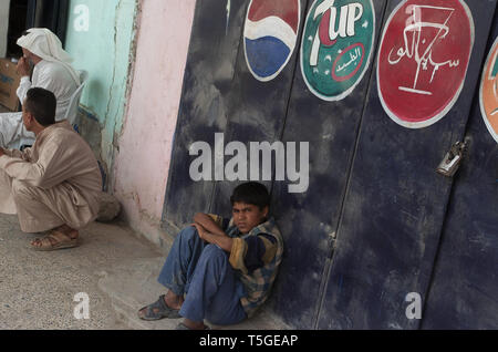 7 mai 2006 -, de Bayji Salah ad Din, l'Iraq - Un garçon iraquien attend d'être remis en question par des soldats iraquiens au cours d'une répression de la vente de l'essence au marché noir par des soldats irakiens et de soldats américains de Abu compagnie, 1er Bataillon, 187e Régiment d'infanterie à Bayji, iraquienne, le 7 mai 2006.Les soldats de l'armée iraquienne, 4e Bataillon, 2e Brigade, 4e Division de l'armée irakienne, et l'American's Abu compagnie, 1er Bataillon, 187e Régiment d'infanterie ont été sévir contre les passeurs et les vendeurs de carburant blackmarket autour de la région de l'Iraq, de Bayji. L'insurrection et les bandes criminelles de leur financement de Banque D'Images