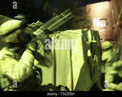 Bagdad, Bagdad, Irak. Nov 7, 2004. Des soldats de troupe, 1er Escadron, 7e régiment de cavalerie couvrir une maison avant d'un raid à Bagdad le 7 novembre 2004. La troupe plus tard arrêté deux hommes qui ont été testés positifs pour une exposition récente à des explosifs. Credit : Bill Putnam/ZUMA/Alamy Fil Live News Banque D'Images