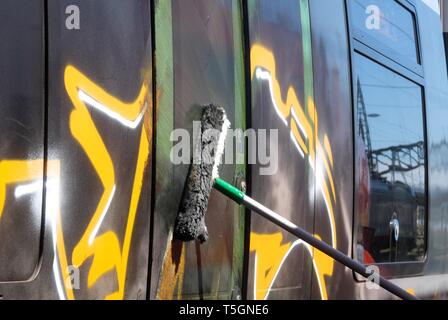 Leipzig, Allemagne. Apr 25, 2019. Un Décapant pour graffitis travaille sur un S-Bahn pulvérisé voiture à la gare centrale de Leipzig. Credit : Sebastian Willnow/dpa-Zentralbild/dpa/Alamy Live News Banque D'Images