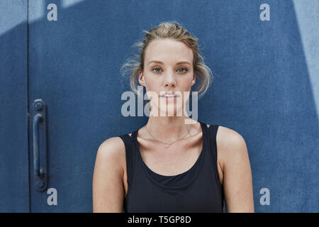Portrait of young woman standing in front of white background Banque D'Images