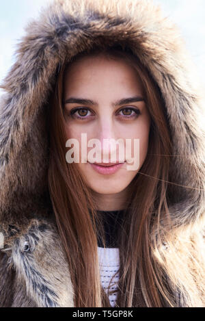 Portrait of beautiful young woman wearing fur hood Banque D'Images
