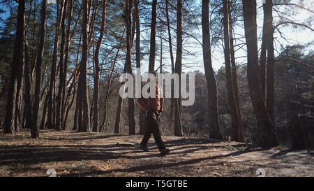 Mâle actif portrait of caucasian man sportive randonnées guy à l'extérieur en forêt de pins. Jeune homme touriste avec barbe et bandage, bandana sur sa tête portant Banque D'Images