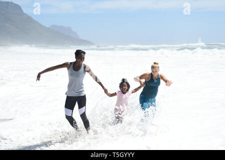 Mère et fille avec tes amis s'amusant à surfer sur la plage Banque D'Images