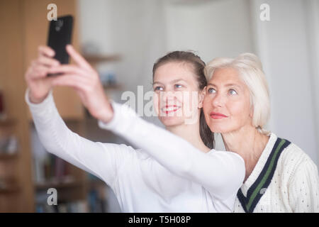 Portrait de jeune femme en tenant avec sa mère selfies Banque D'Images