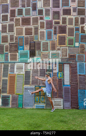 L'INDONÉSIE, Bali, l'homme marchant au mur de fenêtres en bois Banque D'Images