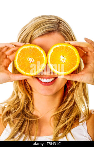 Femme blonde est couvrant les yeux par deux la moitié des fruits orange, sur fond blanc. Banque D'Images