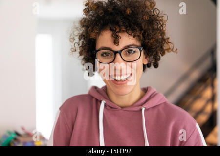 Portrait d'une jeune femme aux cheveux bouclés, portant des lunettes Banque D'Images