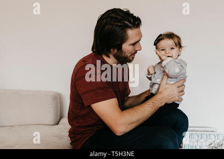 Père holding baby girl at home Banque D'Images