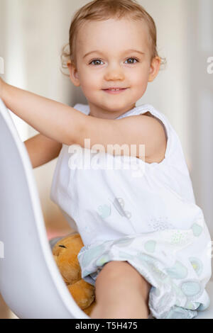 Portrait of smiling woman sitting on a chair Banque D'Images
