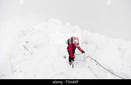 Royaume-uni, Ecosse, Glen Spean, woman climbing crête est un Caorainn de Beinn en hiver Banque D'Images