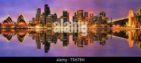 Large panorama de près la ville de Sydney CBD d'horizon de l'autre le port de Sydney au coucher du soleil avec l'éclairage lumineux des tours d'affaires et de mise en miroir ref Banque D'Images